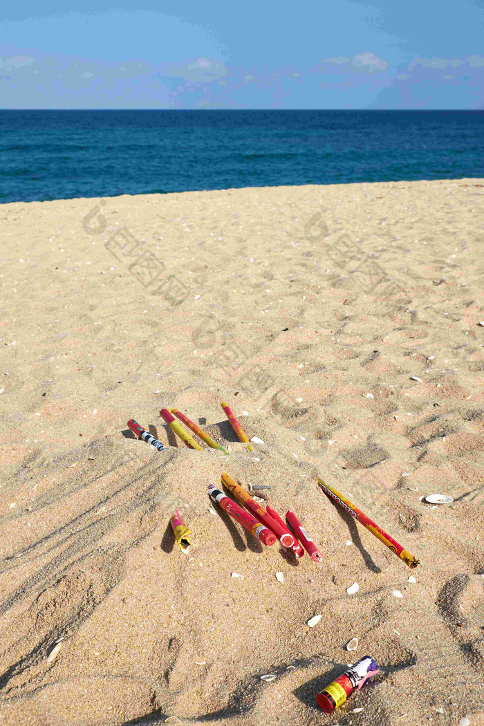 废弃的烟花埋在海边沙土里