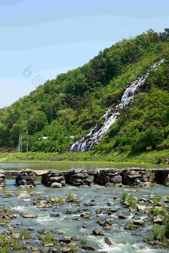 山上流下一股清泉山下石块堆起的桥特写