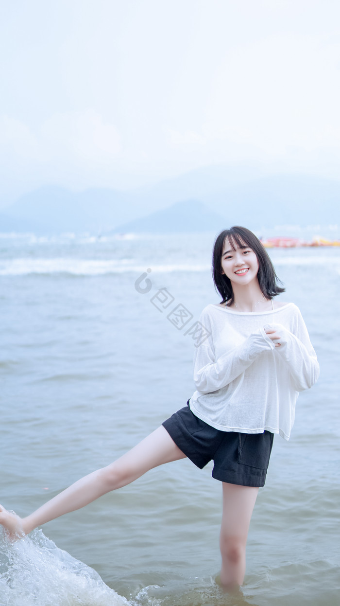 海边玩水大笑的女孩图片