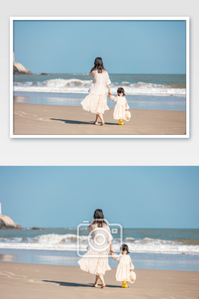 母亲牵着孩子在海边散步