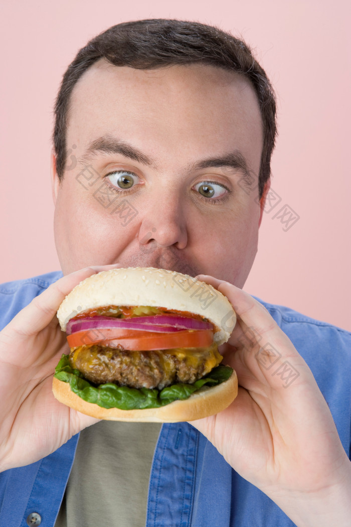 粉色调吃汉堡的人摄影图