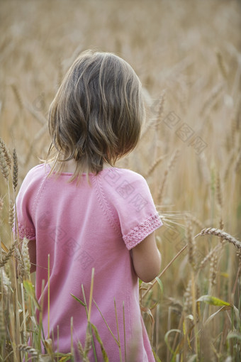 深色调草丛中的小女孩摄影图
