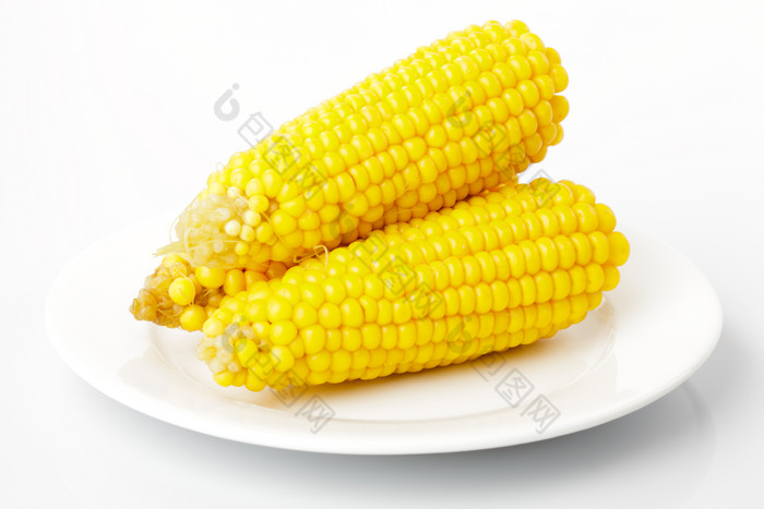 盘子里的玉米棒子摄影图