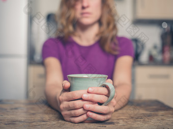 女人双手拿着陶瓷杯