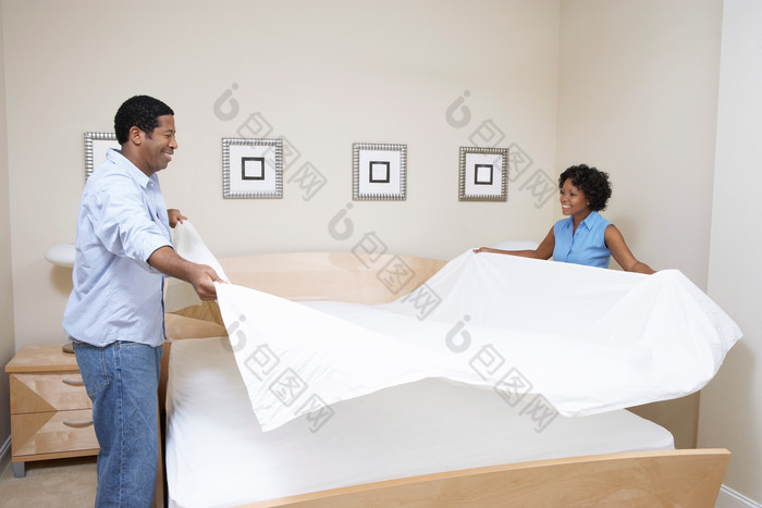 简约整理床单的夫妻摄影图