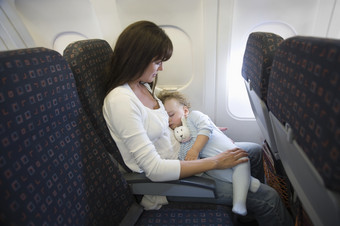 暗色调坐飞机的母子摄影图