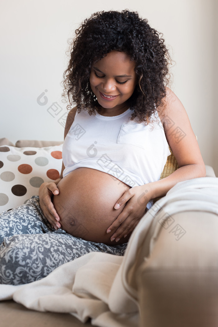 黑人孕妇靠在沙发上抚摸孕肚