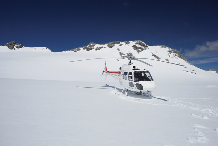 蓝色调雪山上的直升机摄影图