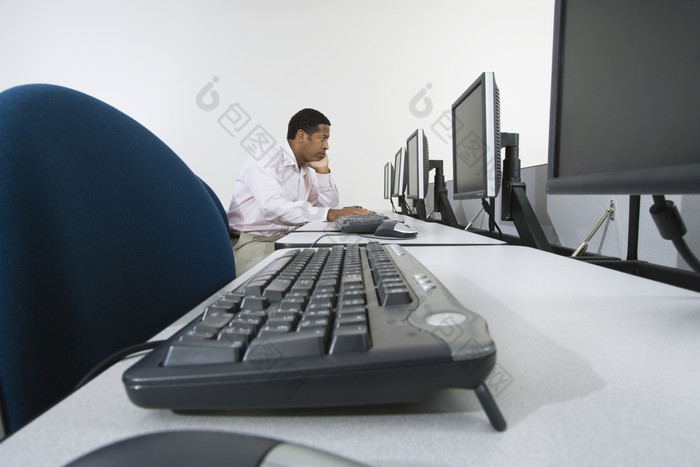 暗色调用电脑的男员工摄影图