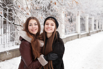 冬天两个女孩开心在雪地玩耍