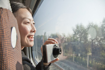 高铁车上相机窗外风景拍摄旅游旅途女孩摄影