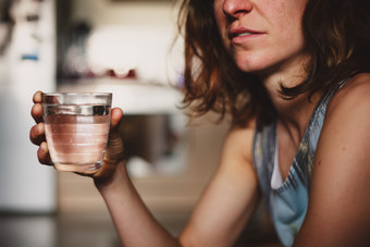 端着一杯水的女人摄影图