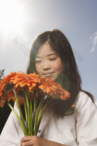 手中拿着橙色鲜花的女孩