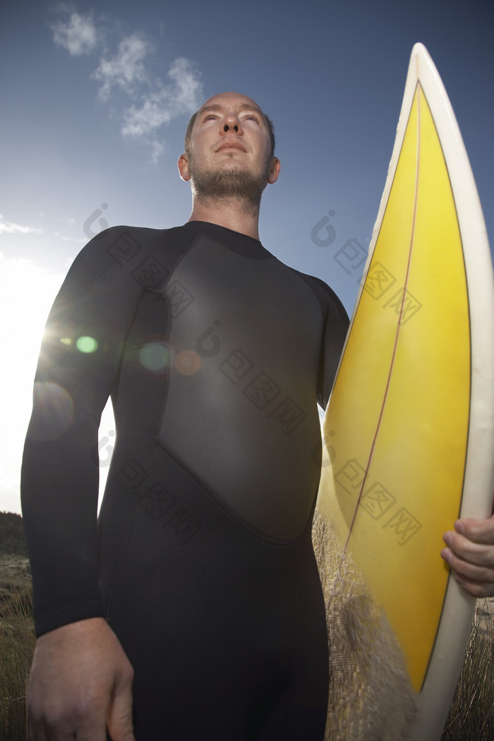 阳光下冲浪者拿着冲浪板