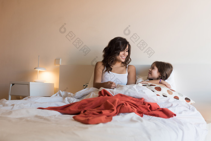 母亲和小孩在床上摄影图