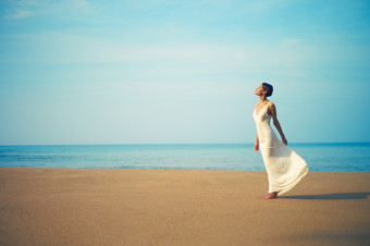蓝色调海边的长裙女人摄影图