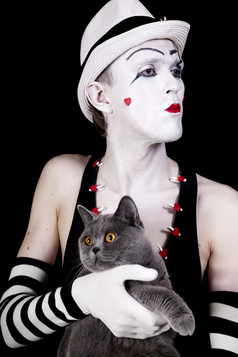 暗色调与猫一起表演的小丑摄影图