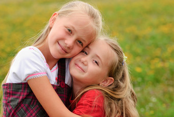 在草地上拥抱的两个小女孩