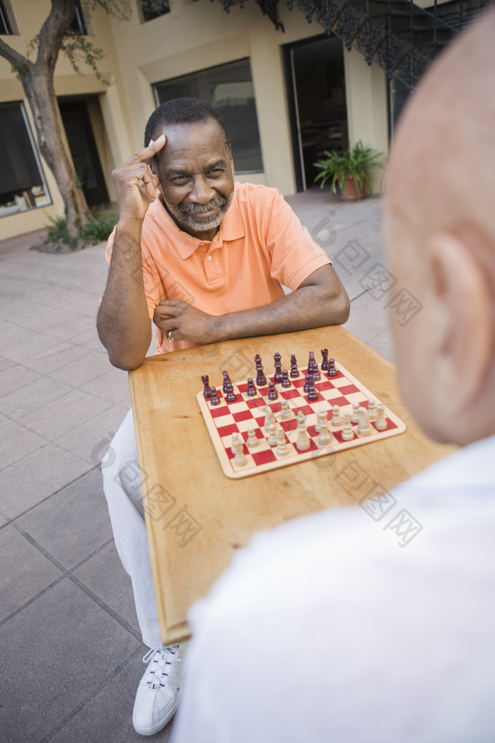深色调下棋的老人们摄影图