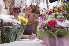鲜花店内坐着写字的女人
