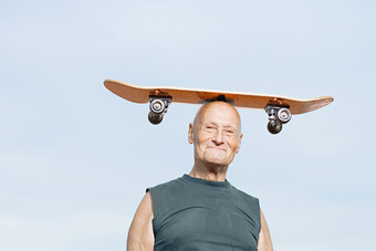 清新顶滑板的老人摄影图