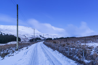 蓝色调雪后的公路摄影图