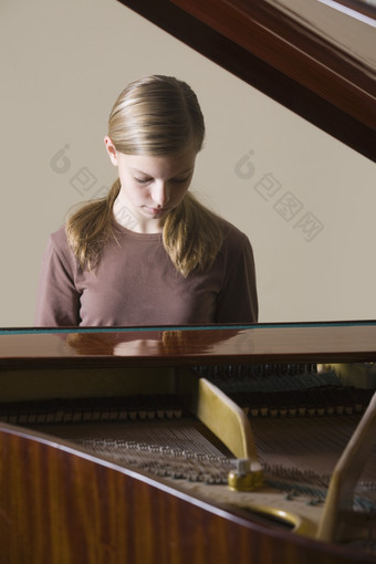 深色调弹<strong>钢琴的</strong>女孩摄影图