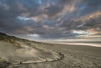 乌云下海滩沙子摄影图