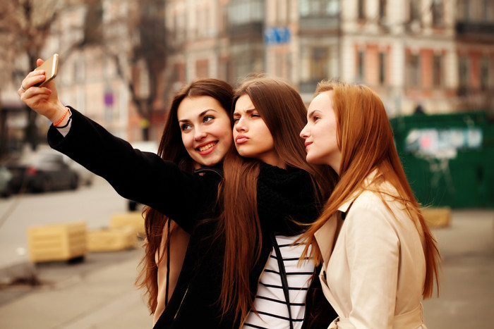三位女孩街头拍照图片