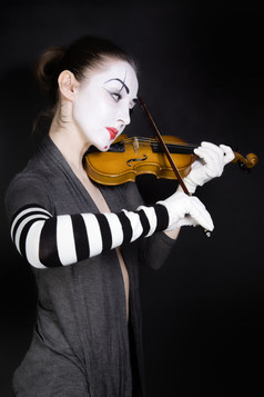 暗色调在拉小提琴的小丑摄影图