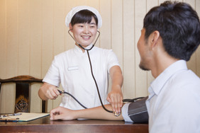 护士听诊男人女人测血压微笑的男人医院