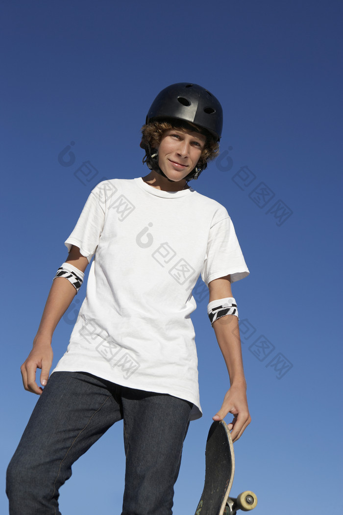 暗色调玩滑板的男孩摄影图