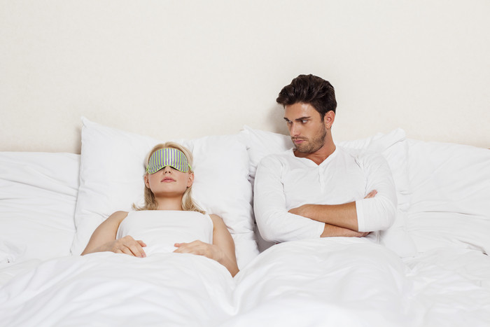 戴眼罩睡觉的夫妻摄影图