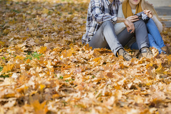坐在秋天落叶上的情侣