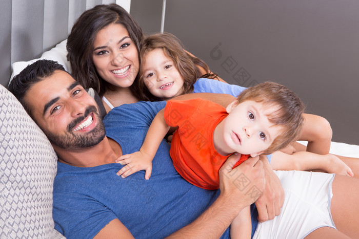 简约风格床上的一家人摄影图