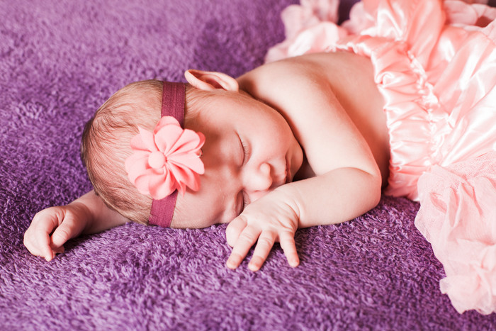 紫色调睡觉的婴儿摄影图
