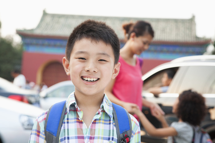 学生小男孩背着书包出游户外旅行微笑景区