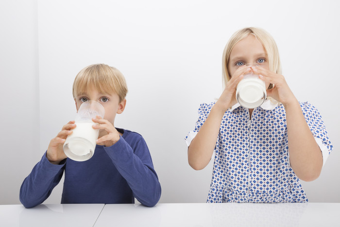 灰色喝牛奶的孩子摄影图