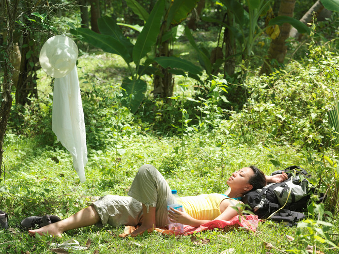 躺在草地上休息的登山女人