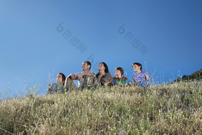 坐山上看风景的一家人