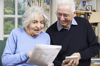 正在读报纸的老年夫妻