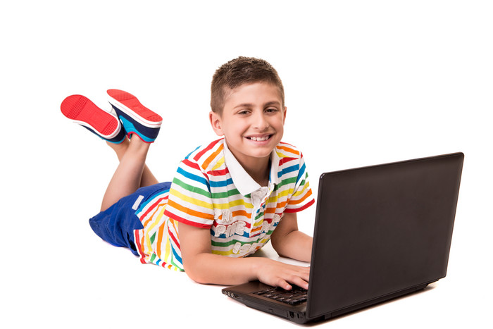 男孩趴在地上玩笔记本电脑