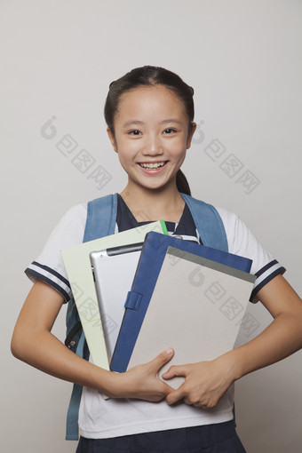 学生小女孩<strong>校服</strong>背着书包手抱着书本学习微笑