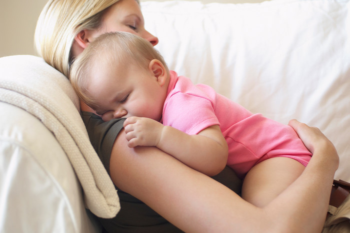 妈妈抱着婴儿睡觉摄影图