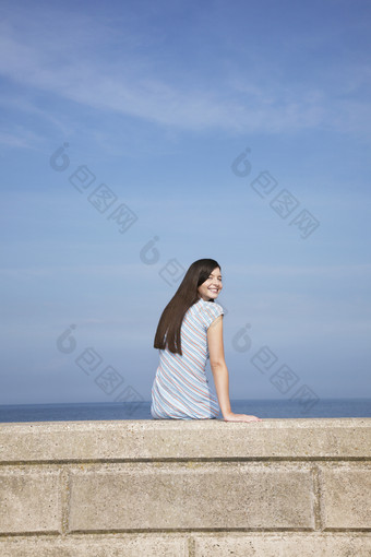 坐在海边石壁上的女人