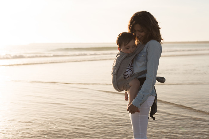 在海边和宝宝一起欣赏美景的妈妈