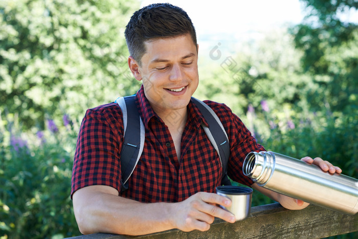 背包男人拿着水壶倒水