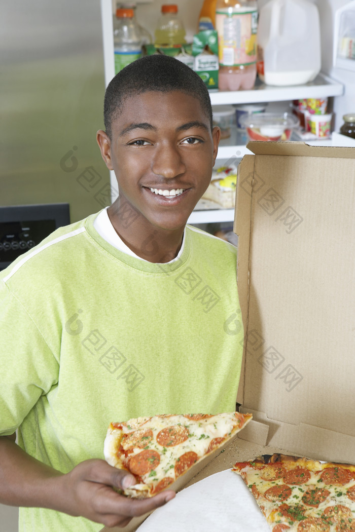 暗色调吃比萨的男孩摄影图
