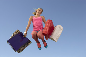 提着购物袋跳跃的女孩