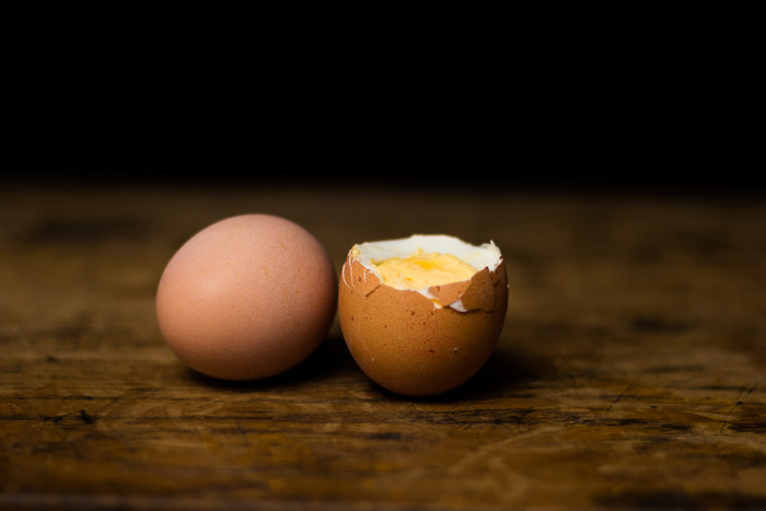 暗色调煮熟的鸡蛋摄影图